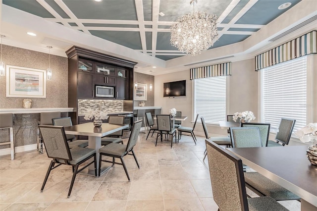 dining area featuring ornamental molding, coffered ceiling, and a notable chandelier