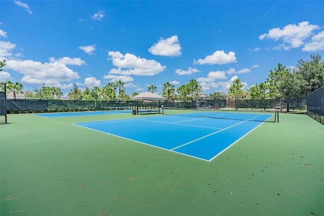 view of tennis court with basketball hoop