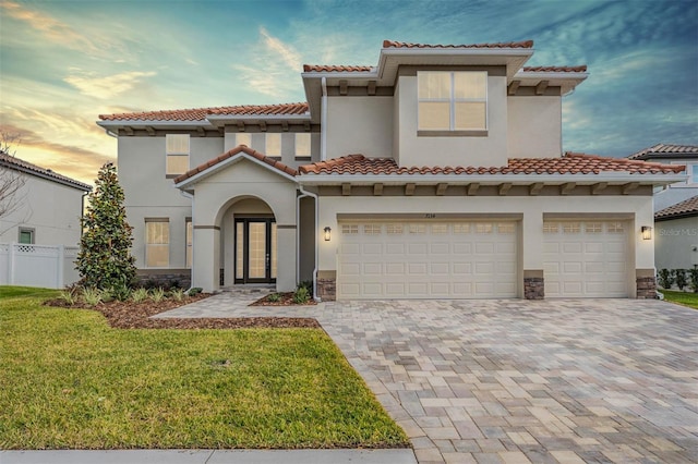 mediterranean / spanish house featuring a lawn and a garage