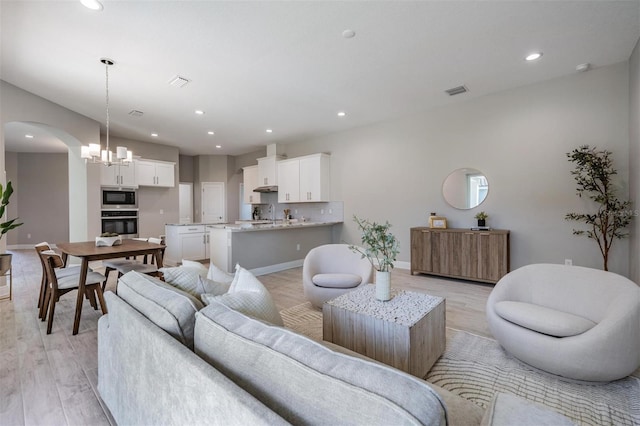 living room featuring light wood-type flooring and a chandelier