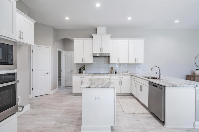 kitchen featuring light stone countertops, sink, stainless steel appliances, kitchen peninsula, and white cabinets