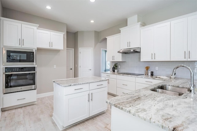 kitchen with black appliances, white cabinetry, and sink