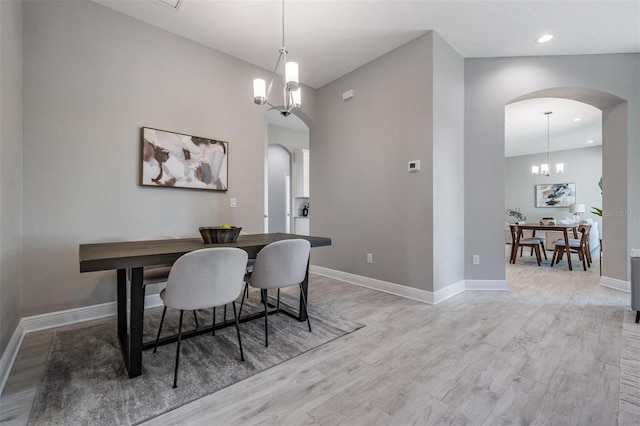 dining room featuring light wood-type flooring and a notable chandelier