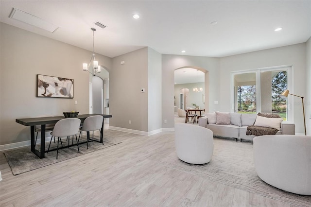 living room with light hardwood / wood-style flooring and an inviting chandelier