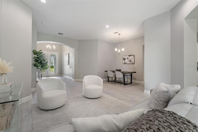 living room with a chandelier and light wood-type flooring