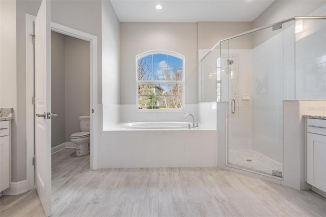 full bathroom featuring hardwood / wood-style floors, vanity, toilet, and plus walk in shower