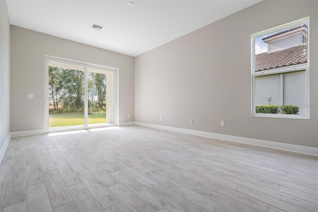 empty room with light hardwood / wood-style flooring and a healthy amount of sunlight