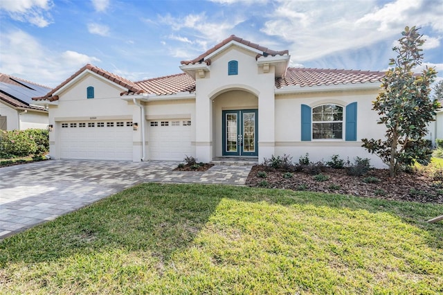 mediterranean / spanish-style house featuring french doors, a front yard, and a garage