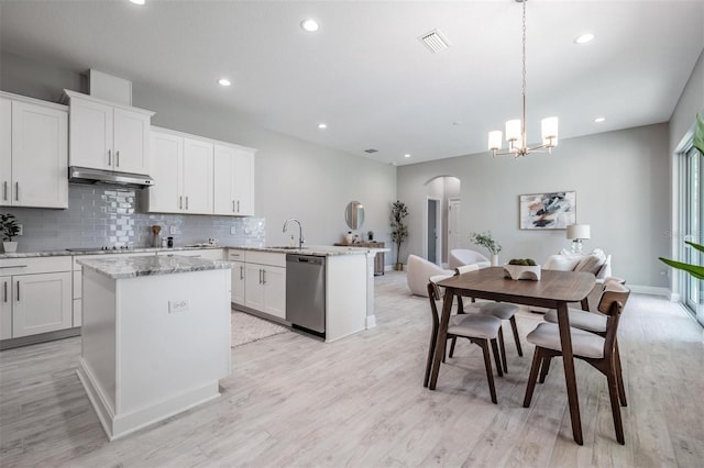 kitchen featuring dishwasher, light hardwood / wood-style floors, and hanging light fixtures