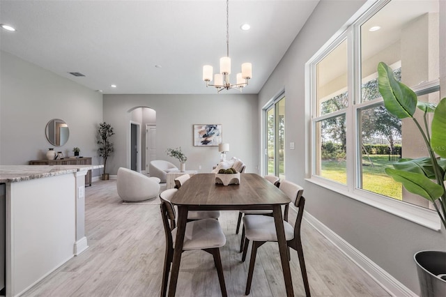 dining area with a chandelier and light hardwood / wood-style flooring