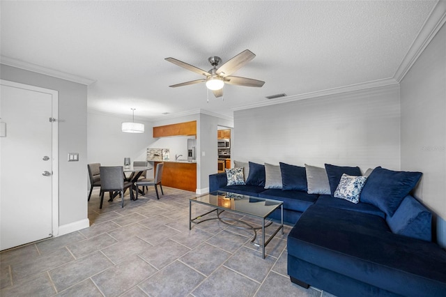 living room with a textured ceiling, ceiling fan, and ornamental molding