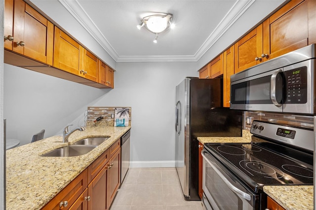 kitchen with appliances with stainless steel finishes, light stone counters, crown molding, sink, and light tile patterned floors