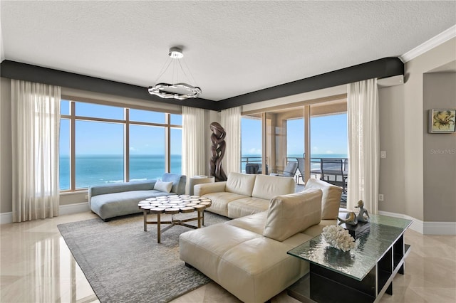 living area with a healthy amount of sunlight, a water view, baseboards, and a textured ceiling