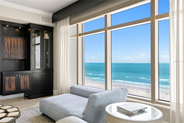 interior space featuring a beach view, ornamental molding, and a water view