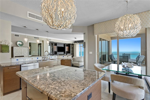 kitchen featuring open floor plan, visible vents, a notable chandelier, and a sink