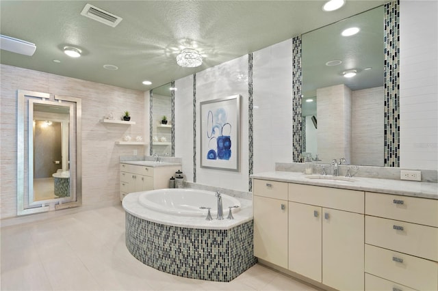 full bathroom with tile patterned flooring, a sink, visible vents, tile walls, and a bath