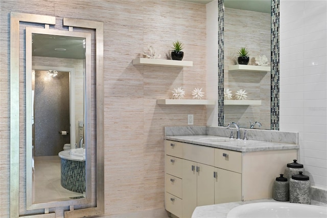 bathroom with tile walls, toilet, and vanity