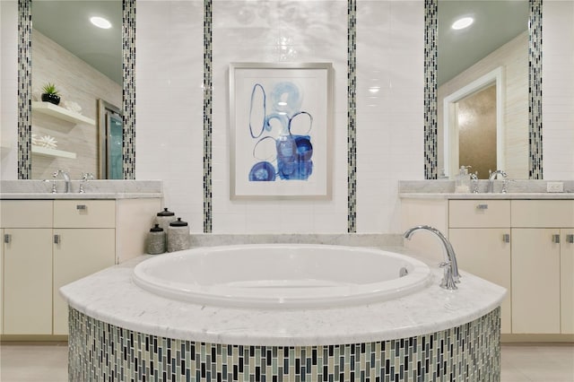 bathroom with two vanities, a garden tub, and tile walls