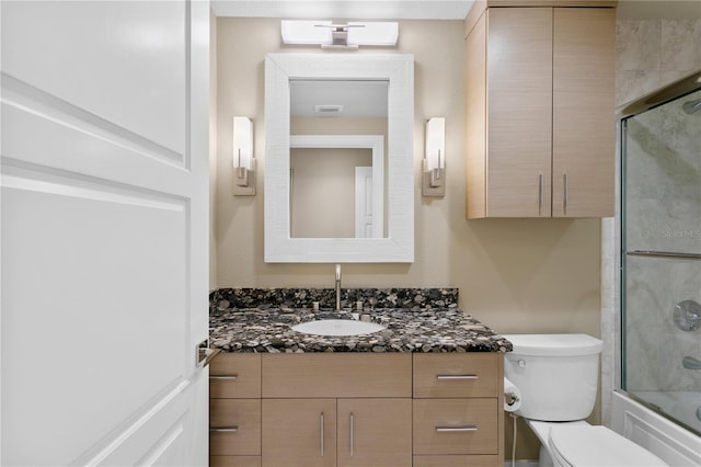 full bathroom featuring vanity, toilet, and combined bath / shower with glass door