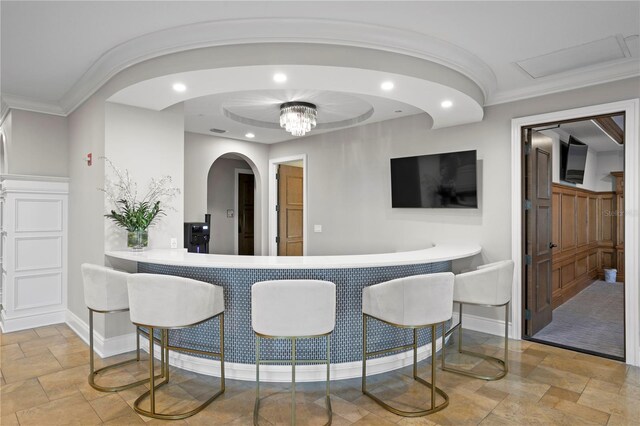 bar featuring crown molding and light tile patterned flooring