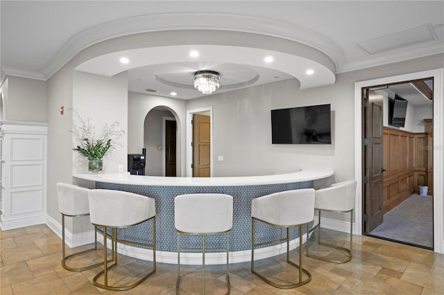 bar featuring baseboards, ornamental molding, stone tile flooring, a chandelier, and recessed lighting