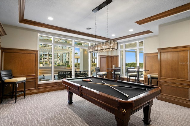 recreation room with carpet, visible vents, a raised ceiling, and ornamental molding