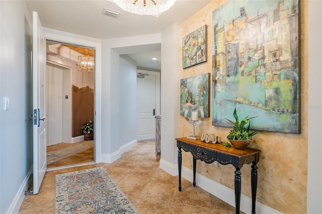 corridor featuring light tile patterned flooring and a notable chandelier