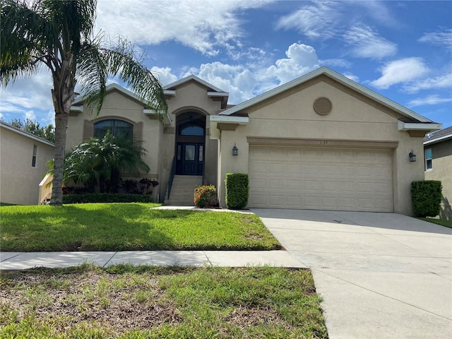 view of front of home featuring a garage, concrete driveway, a front lawn, and stucco siding