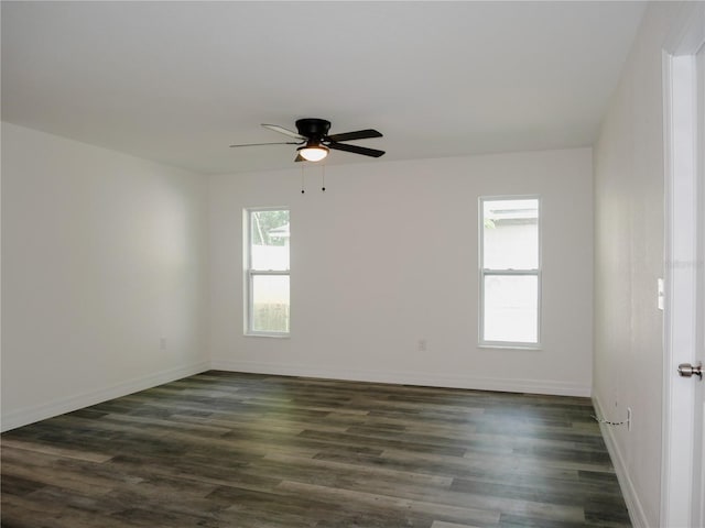 empty room featuring baseboards, dark wood-type flooring, and a ceiling fan