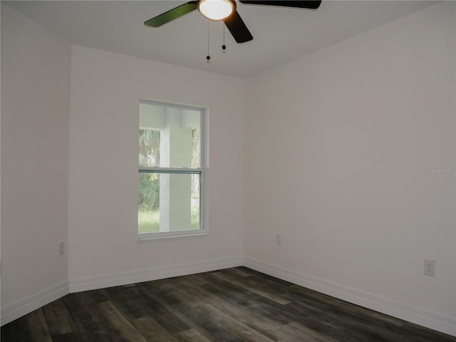 spare room featuring dark wood finished floors, baseboards, and ceiling fan