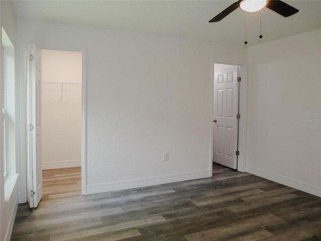 empty room with wood finished floors, baseboards, and ceiling fan