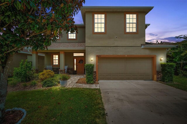 front of property with a lawn and a garage