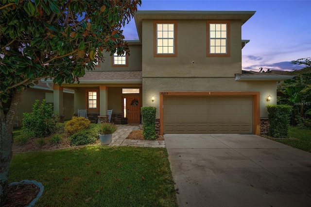 front facade featuring a garage and a lawn