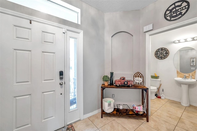 tiled entrance foyer featuring a textured ceiling