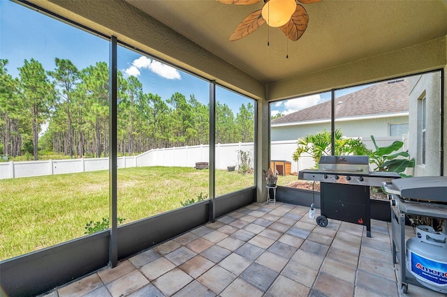 unfurnished sunroom featuring ceiling fan