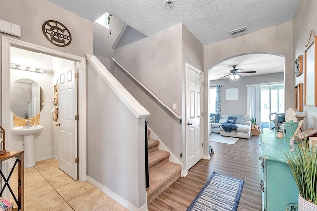 stairway featuring ceiling fan, a textured ceiling, and hardwood / wood-style flooring