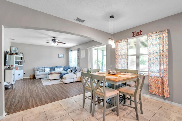 dining room with a textured ceiling, ceiling fan, and light tile patterned floors