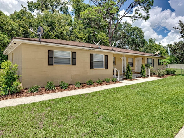 ranch-style house featuring covered porch and a front lawn