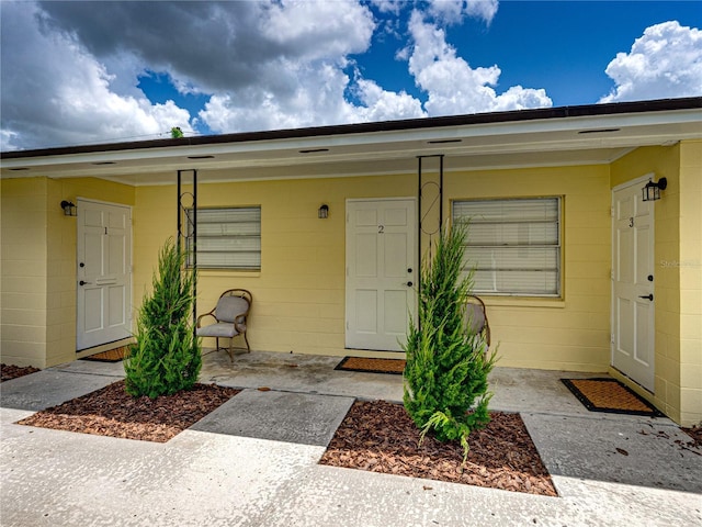 view of exterior entry with a patio area