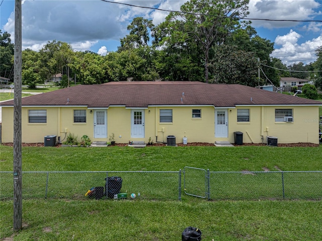 back of property featuring cooling unit and a lawn