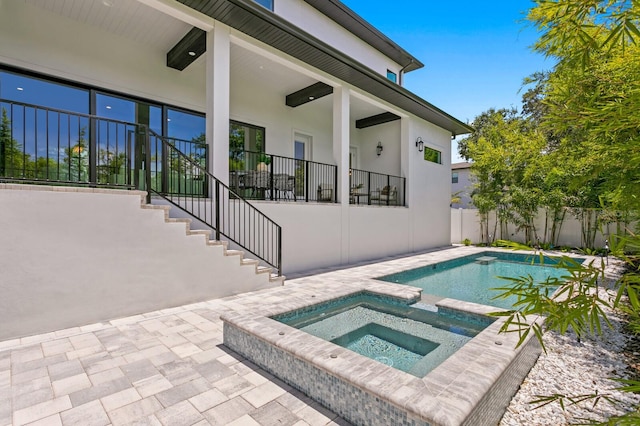 view of pool with an in ground hot tub and a patio area