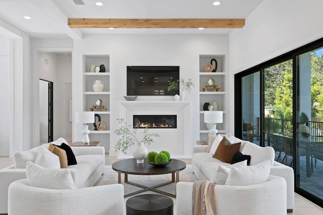 living room with beamed ceiling, built in shelves, and light hardwood / wood-style flooring