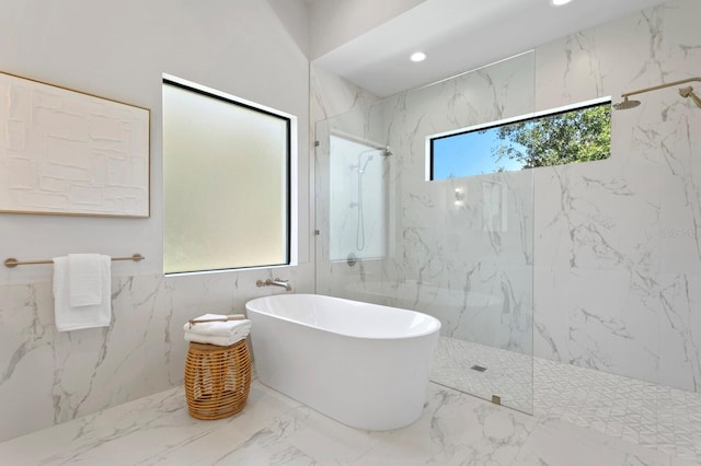 bathroom featuring shower with separate bathtub, tile walls, and tile patterned floors