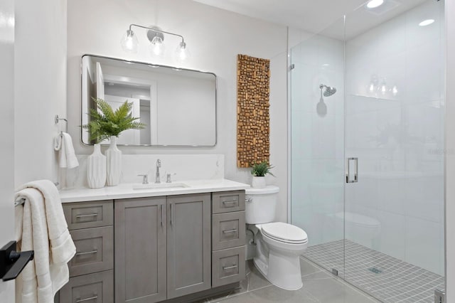 bathroom with an enclosed shower, vanity, toilet, and tile patterned flooring