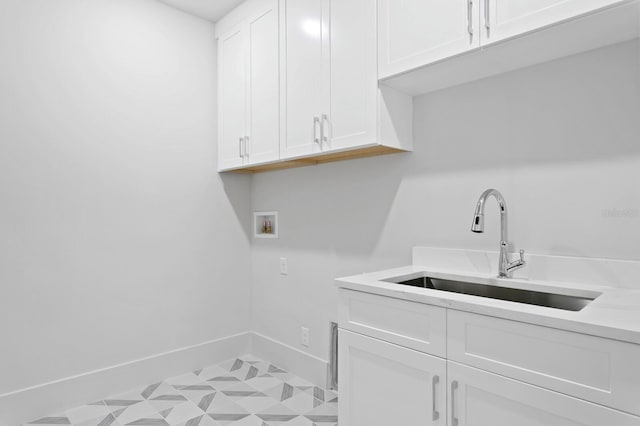 laundry room with hookup for a washing machine, light tile patterned flooring, cabinets, and sink