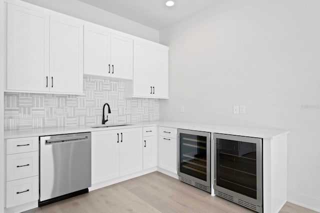 kitchen featuring stainless steel dishwasher, wine cooler, sink, and light hardwood / wood-style floors