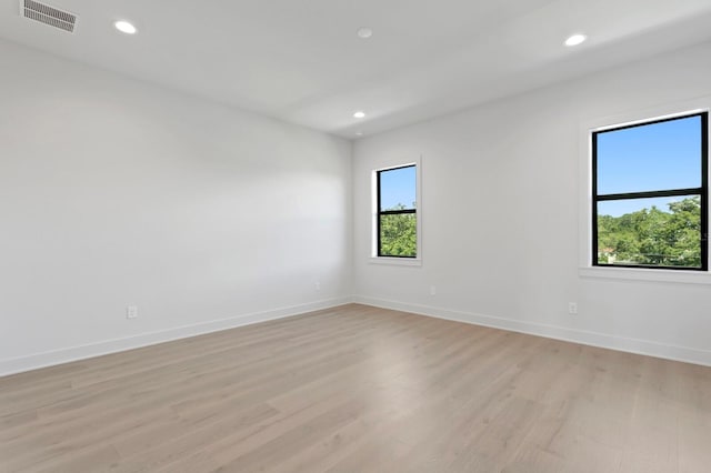 unfurnished room featuring plenty of natural light and light hardwood / wood-style floors