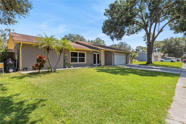 single story home with a garage and a front lawn