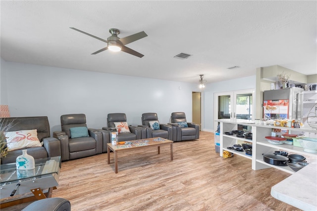 living room featuring light hardwood / wood-style flooring, ceiling fan, and french doors