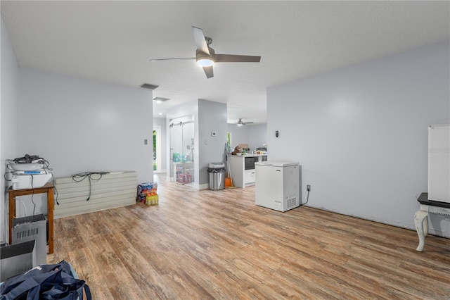 living room with light hardwood / wood-style flooring and ceiling fan